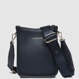 Navy handbag with matching strap on a light gray background