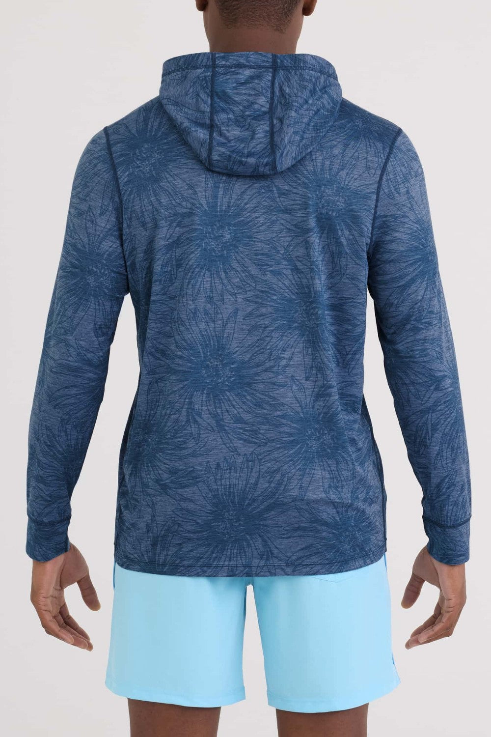 Person wearing a blue patterned hoodie and light blue shorts on a white background