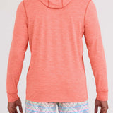Person wearing a coral hoodie and patterned shorts on a white background