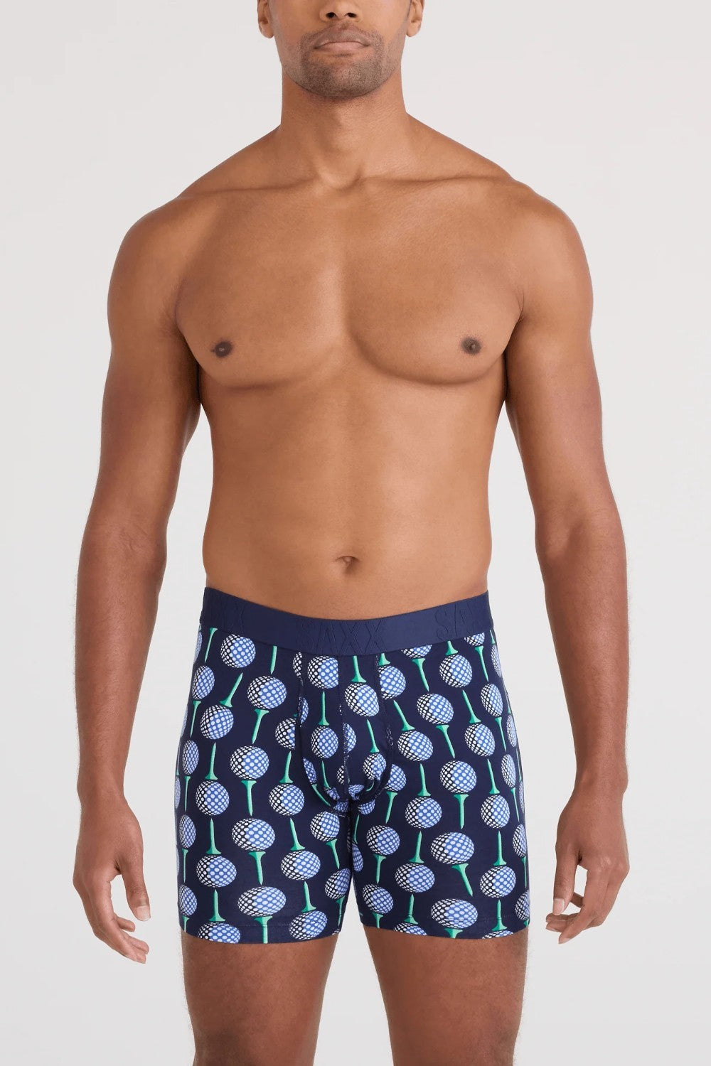 Man wearing navy boxer briefs with a pattern on a white background