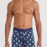 Man wearing navy boxer briefs with a pattern on a white background