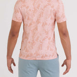 Person wearing a pink floral shirt and light blue shorts on a white background