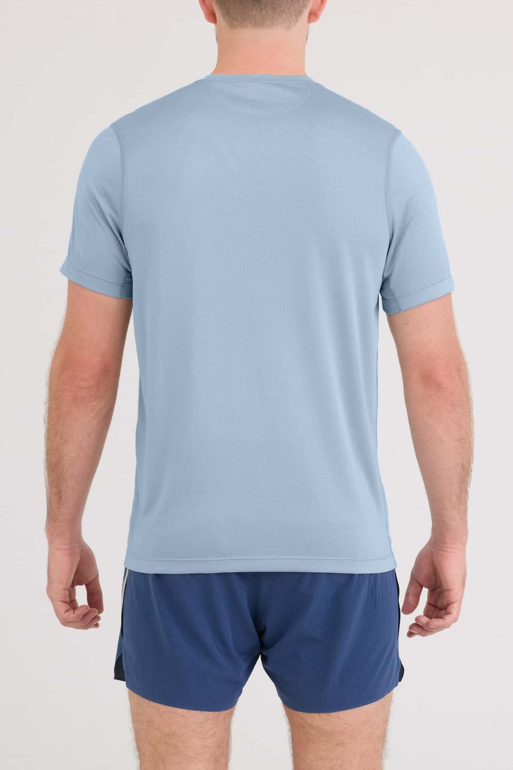 Person wearing a light blue t-shirt and navy shorts on a white background