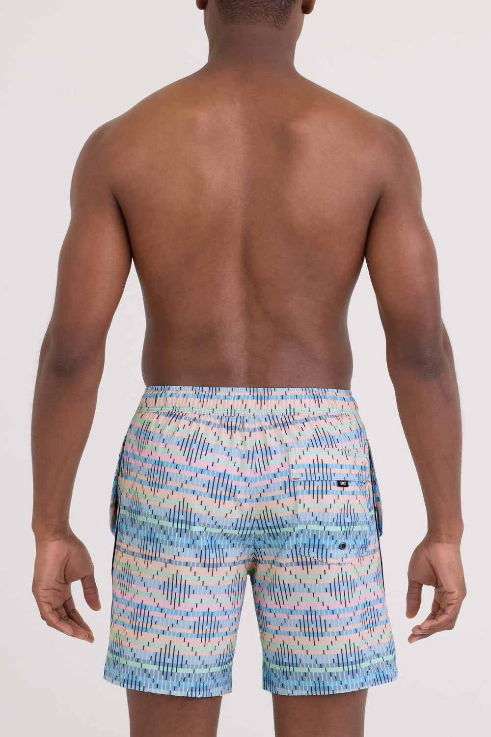 Person wearing colorful patterned swim shorts on a white background