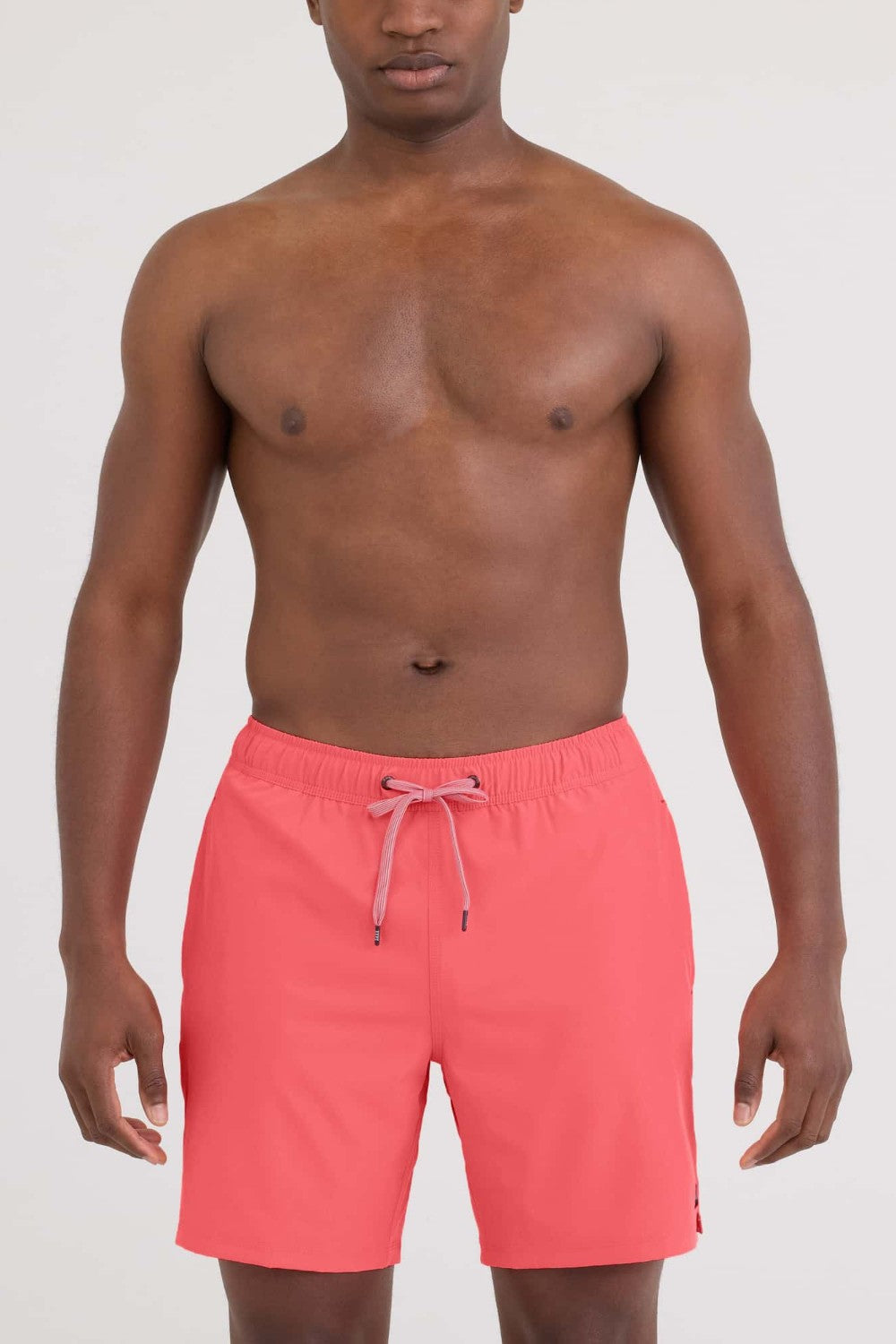 Man wearing pink swim shorts on a white background
