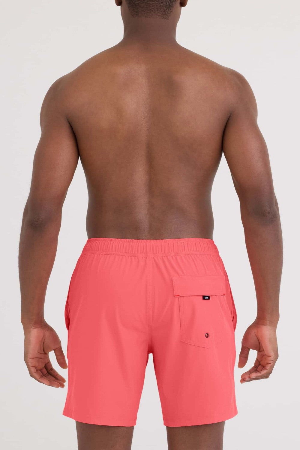 Person wearing coral swim shorts on a white background