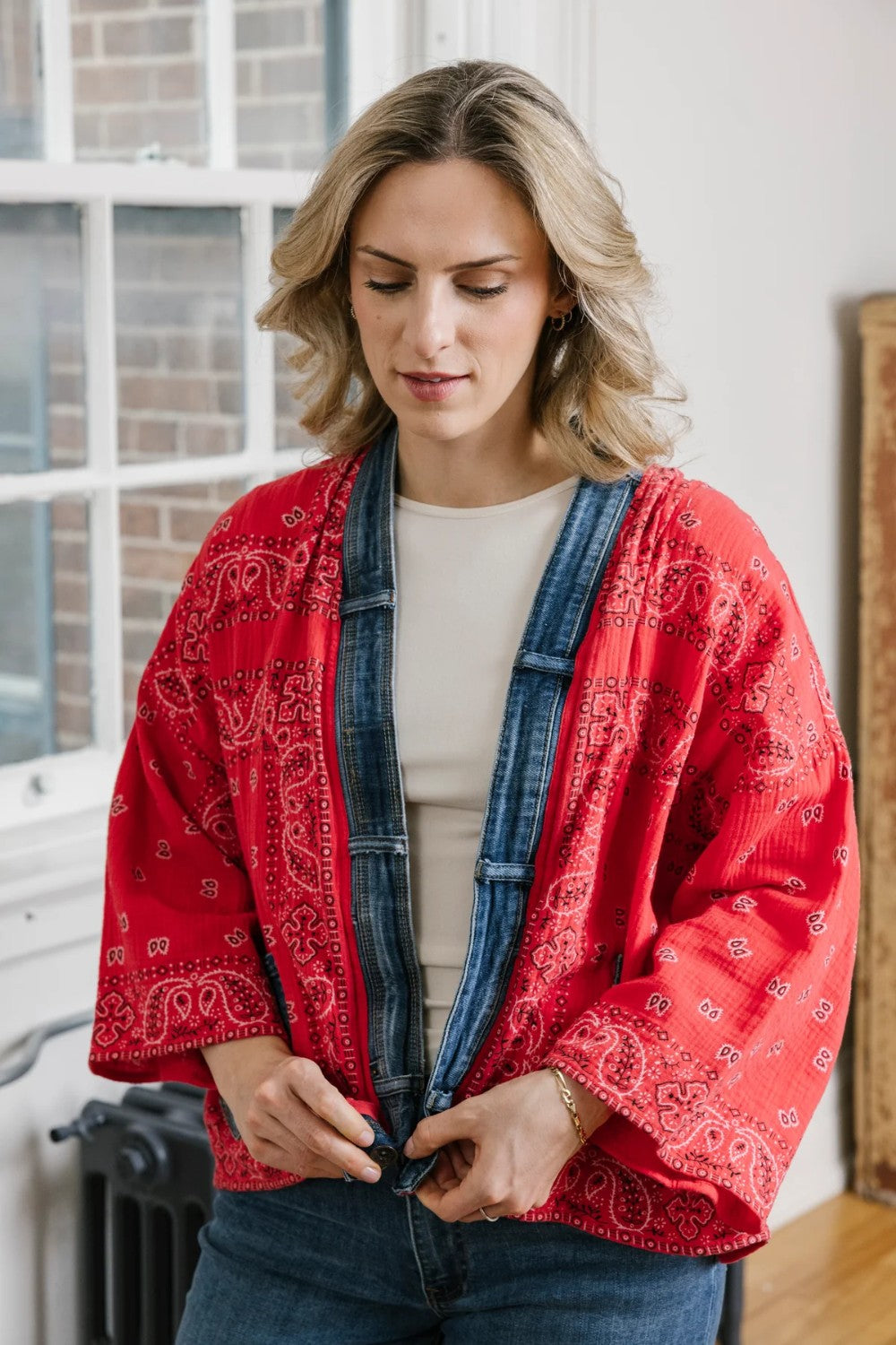 Woman wearing a red patterned cardigan in an indoor setting