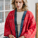 Woman wearing a red patterned cardigan in an indoor setting