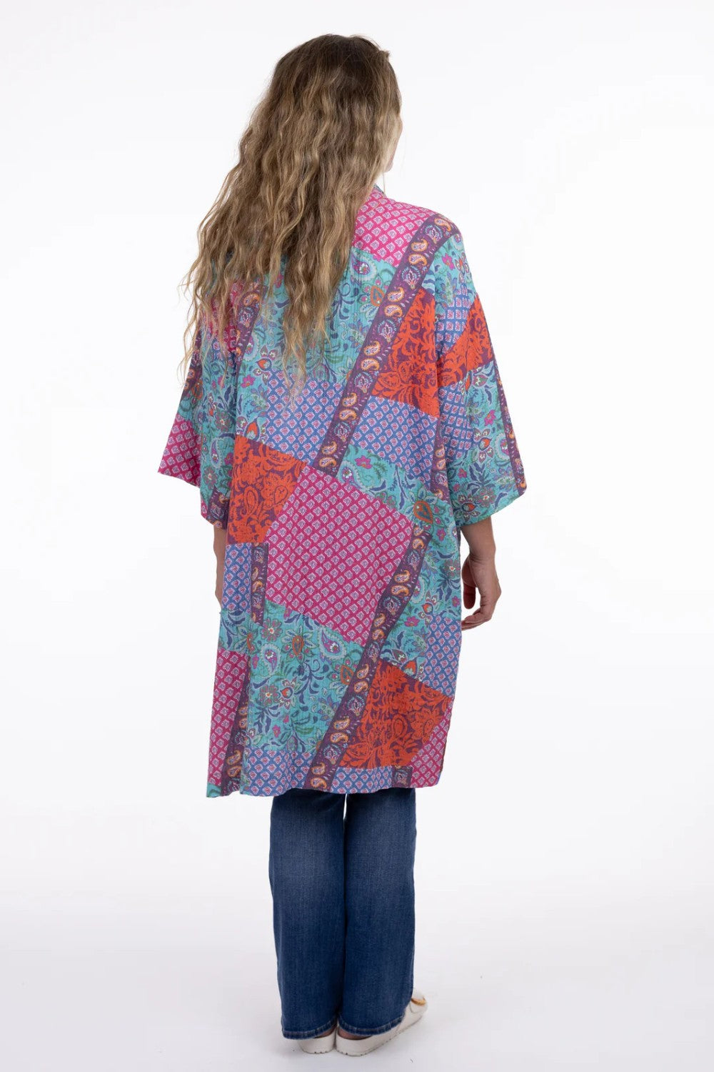 Person wearing a colorful patterned kimono-style garment on a white background