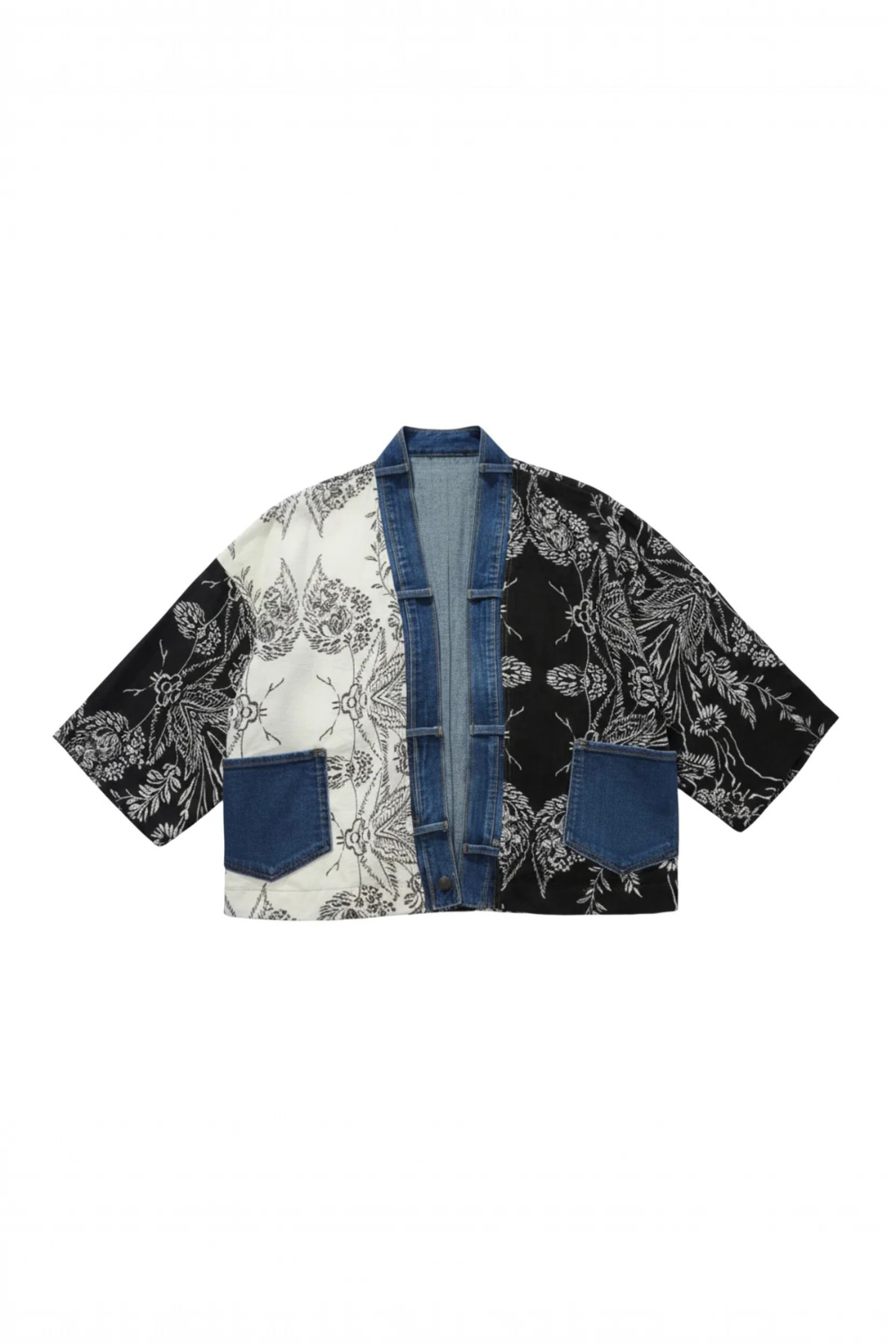 A cropped open-front jacket featuring a patchwork design with a white and black floral print, solid black floral print, and blue denim panels and trim, displayed flat against a white background.
