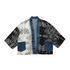 A cropped open-front jacket featuring a patchwork design with a white and black floral print, solid black floral print, and blue denim panels and trim, displayed flat against a white background.