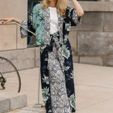 Woman wearing a palm print kimono standing on steps outdoors