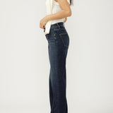 Woman wearing dark blue jeans and a white top on a white background