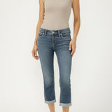 Woman wearing a beige tank top and blue jeans on a white background