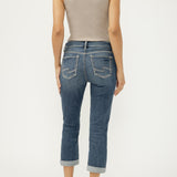 Person wearing a beige tank top and blue jeans on a white background