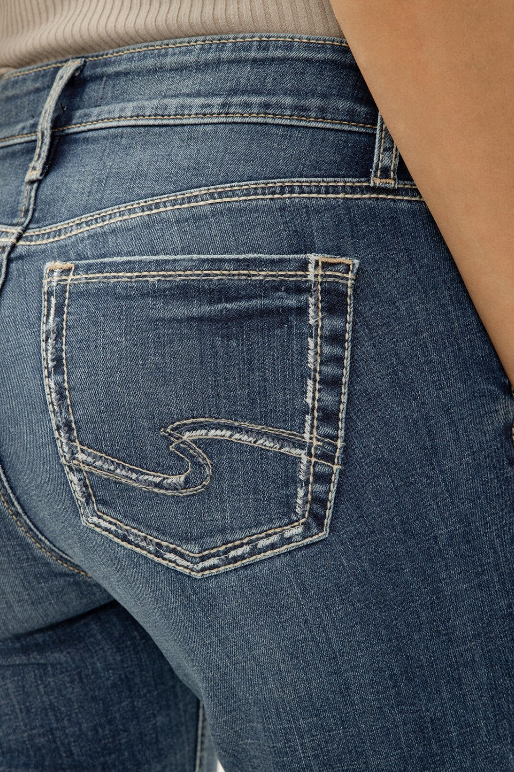 Close-up of blue jeans with a brand logo on the pocket.