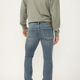 Person wearing a green sweatshirt and blue jeans on a white background