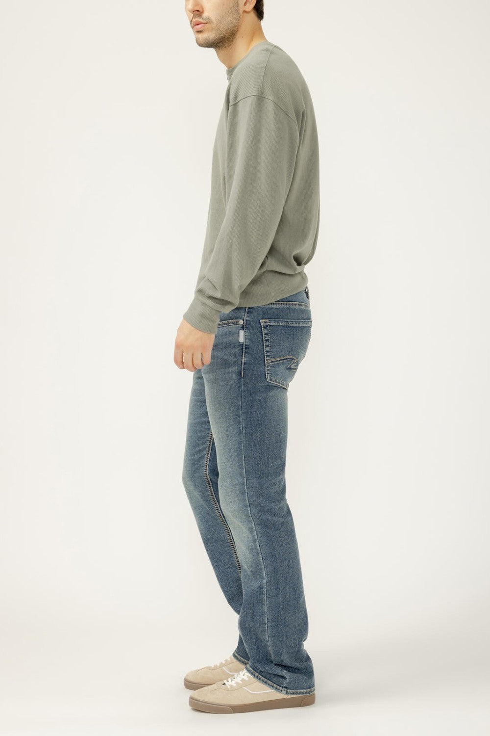 Person wearing a green sweatshirt and blue jeans on a white background