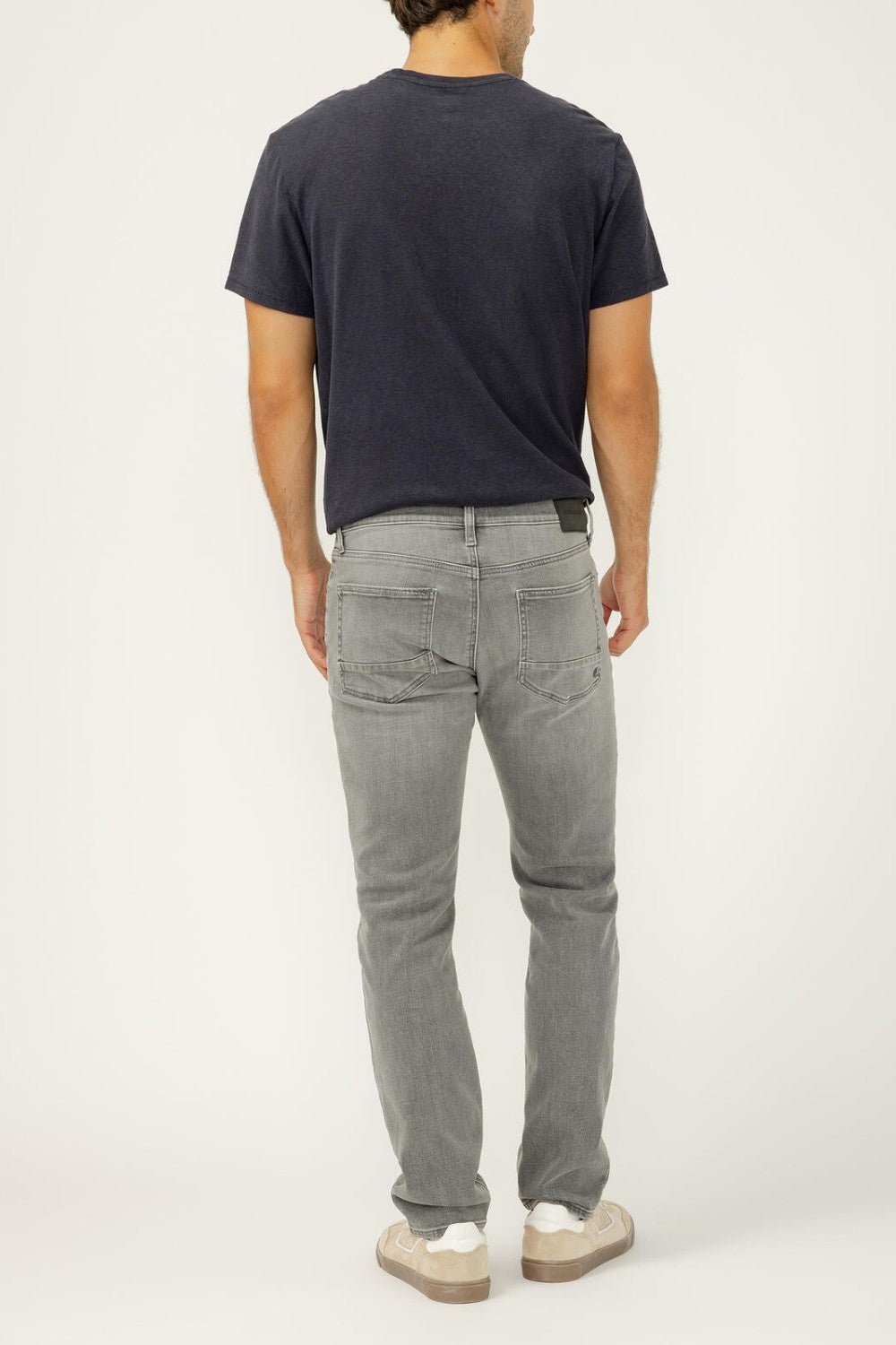 Person wearing a black t-shirt and gray jeans on a white background