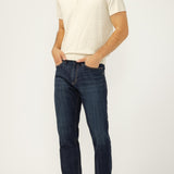 Man wearing a white polo shirt and dark blue jeans on a white background