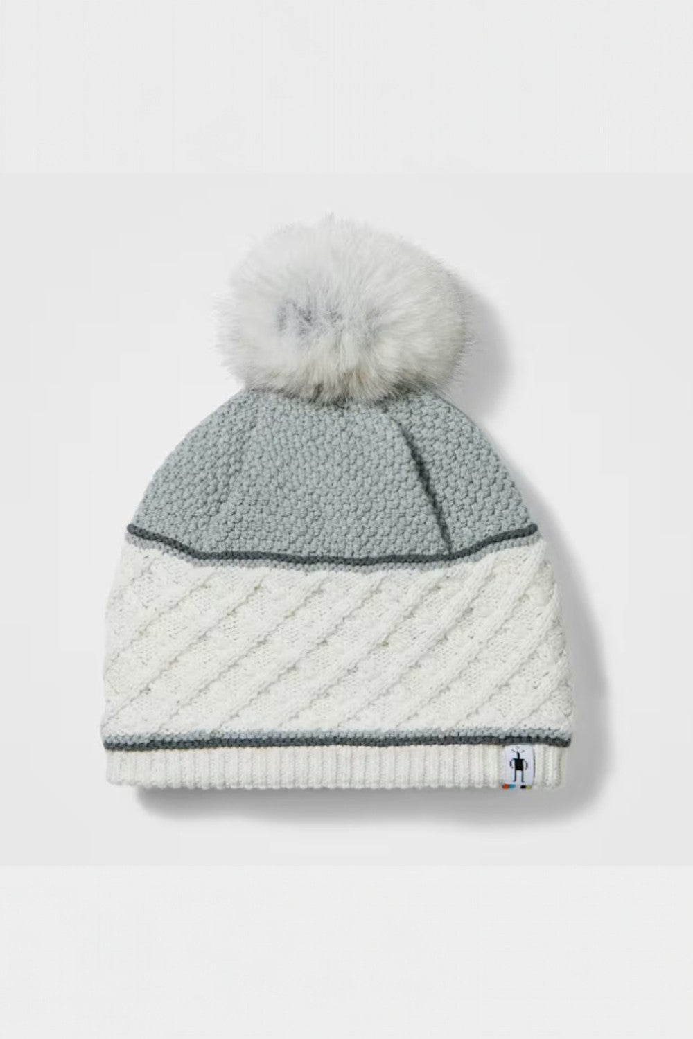 Knitted beanie with gray top and white bottom on a light gray background