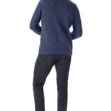 Man wearing a blue sweater and dark jeans on a white background