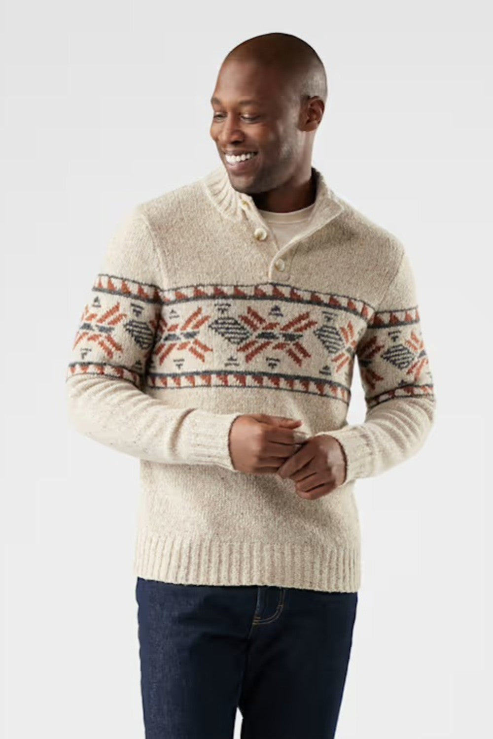 Man wearing a cream-coloured sweater with a patterned design on a light gray background