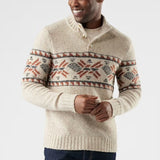 Man wearing a cream-coloured sweater with a patterned design on a light gray background