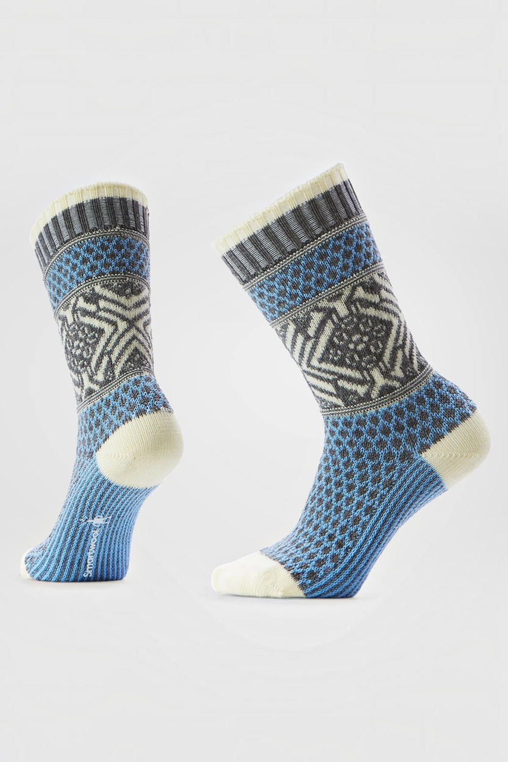 A pair of crew socks with a blue, gray, and cream Nordic pattern, shown on a light gray background.
