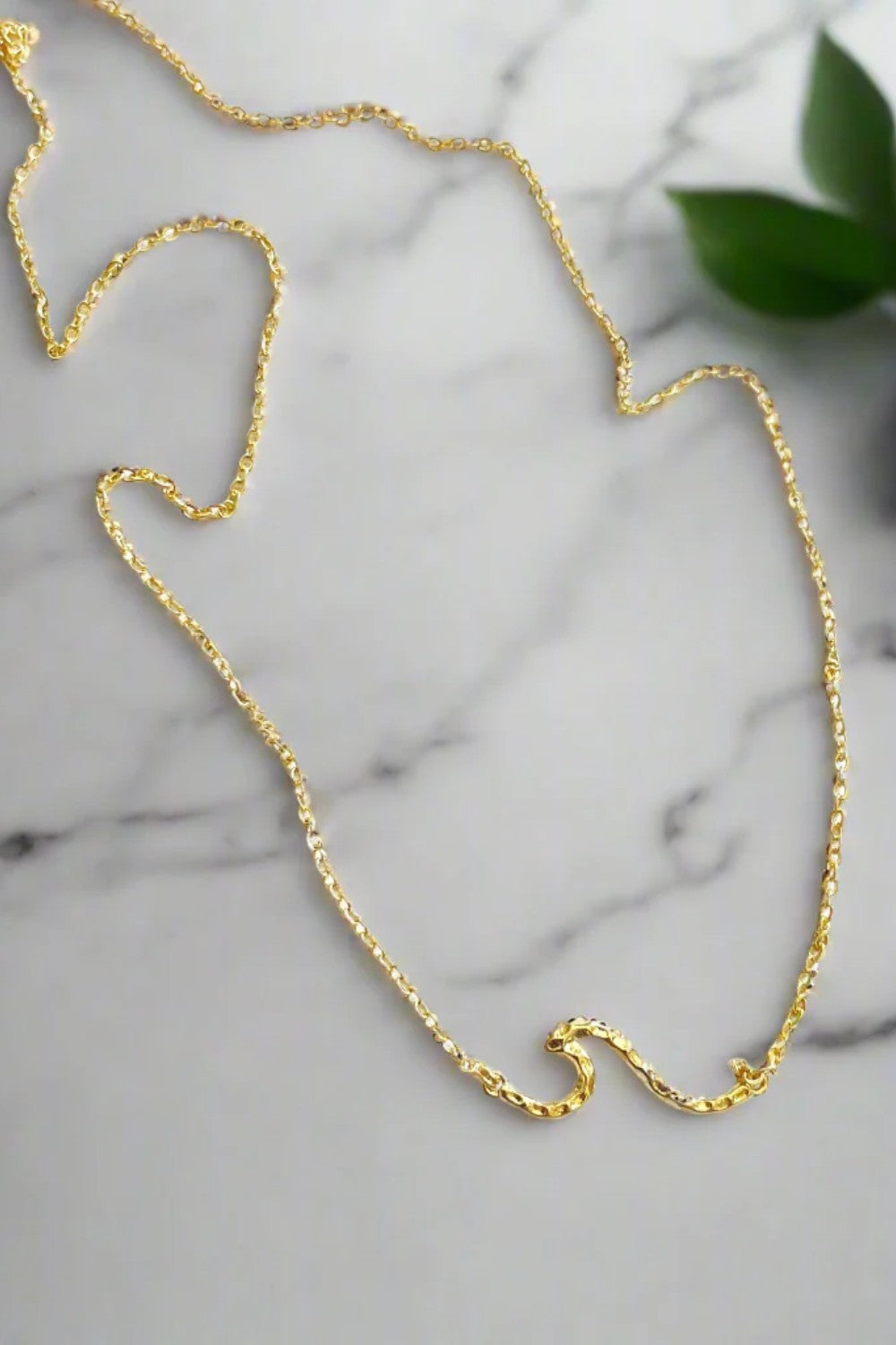Ride the wave with this Chainlink Necklace featuring a handmade wave pendant. Gold plated for a delicate touch, this necklace is perfect for any occasion.