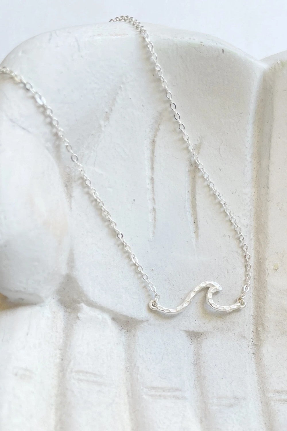 Ride the wave with this Chainlink Necklace featuring a handmade wave pendant. Silver plated for a delicate touch, this necklace is perfect for any occasion.