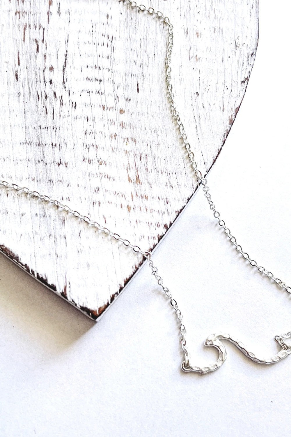 Ride the wave with this Chainlink Necklace featuring a handmade wave pendant. Silver plated for a delicate touch, this necklace is perfect for any occasion.