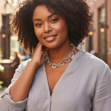 Woman wearing a silver chain necklace outdoors with blurred background