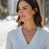 Woman wearing a necklace outdoors with blurred background