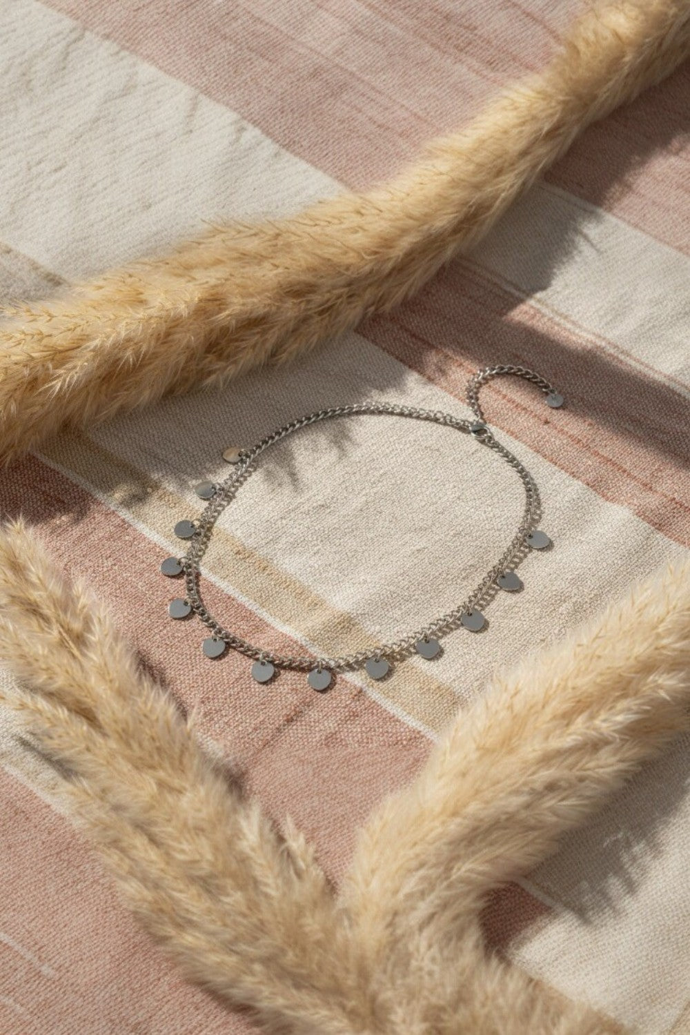Necklace with small heart pendants on a textured surface with fur accents