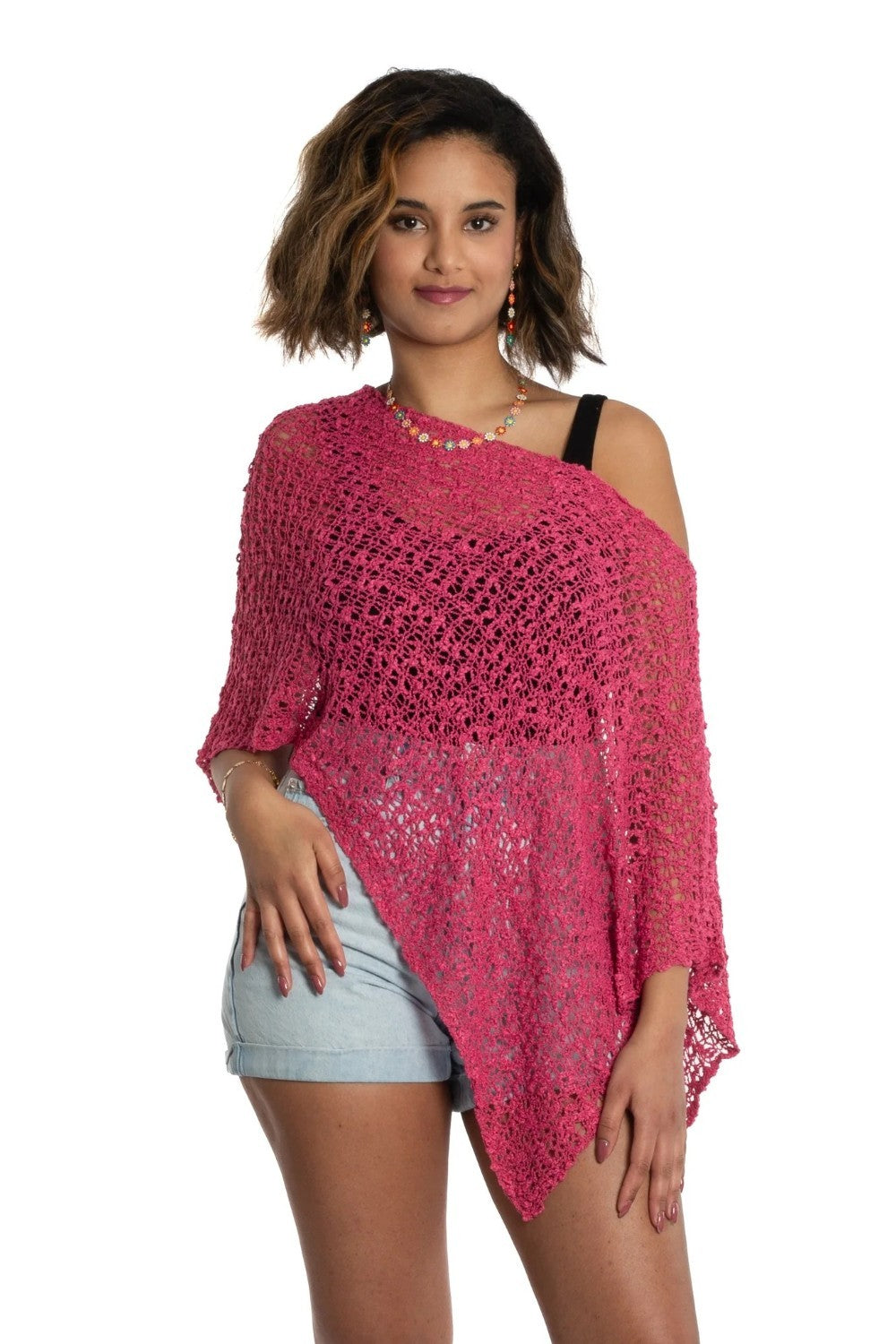 Woman wearing a pink crochet cover-up on a white background