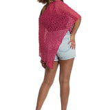 Woman wearing a pink knitted shawl over a white background