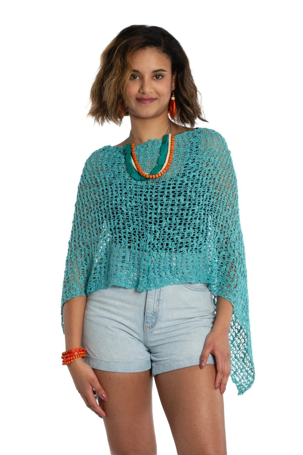 Woman wearing a turquoise knitted top and light blue shorts on a white background