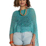 Woman wearing a turquoise knitted top and light blue shorts on a white background