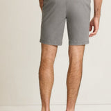 Person wearing gray shorts on a plain background