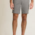 Person wearing gray shorts on a beige background