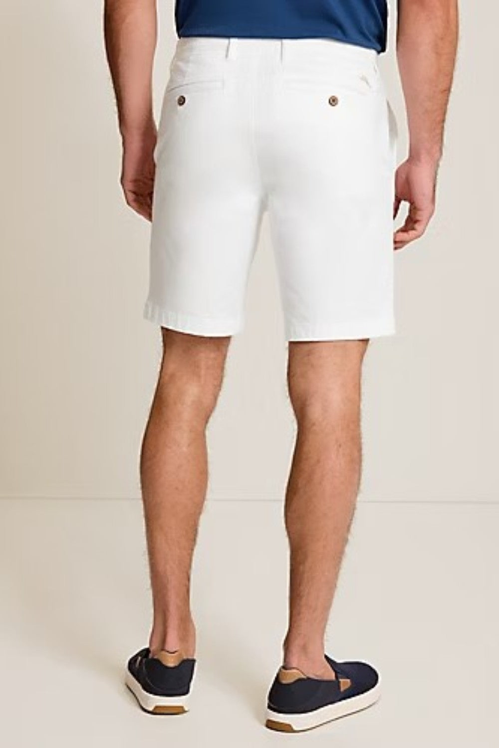 Person wearing white shorts with a plain background