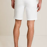 Person wearing white shorts with a plain background