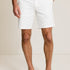 Person wearing white shorts and navy shoes on a plain background