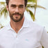 Man wearing a white polo shirt with a logo outdoors