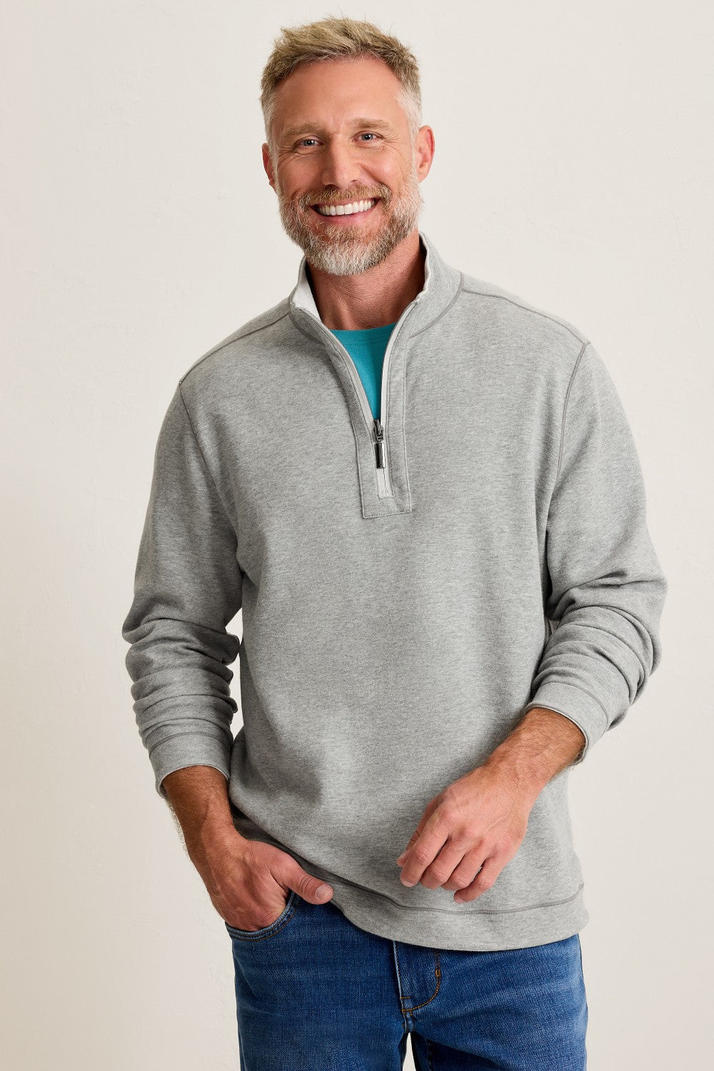 Man wearing a gray pullover with a white background