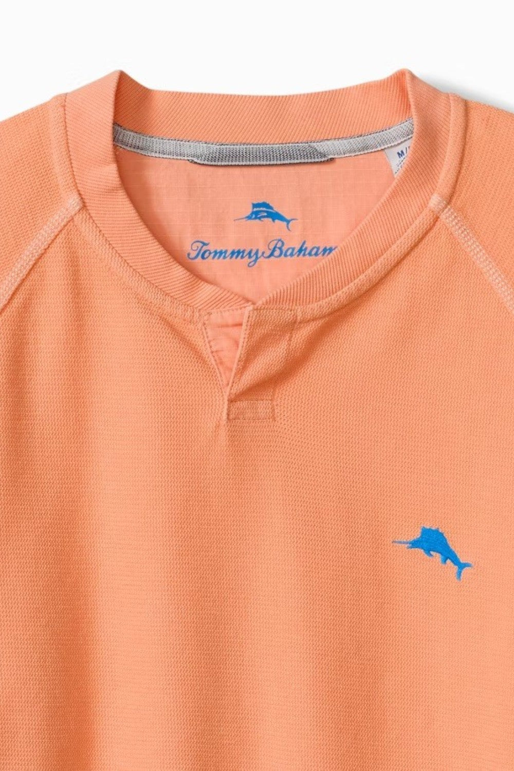 Orange shirt with Tommy Bahama logo on a light blue background