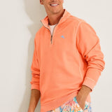 Man wearing a coral long-sleeve shirt and colorful floral shorts against a white background