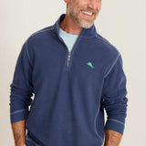Man wearing a blue pullover with a logo on a light background