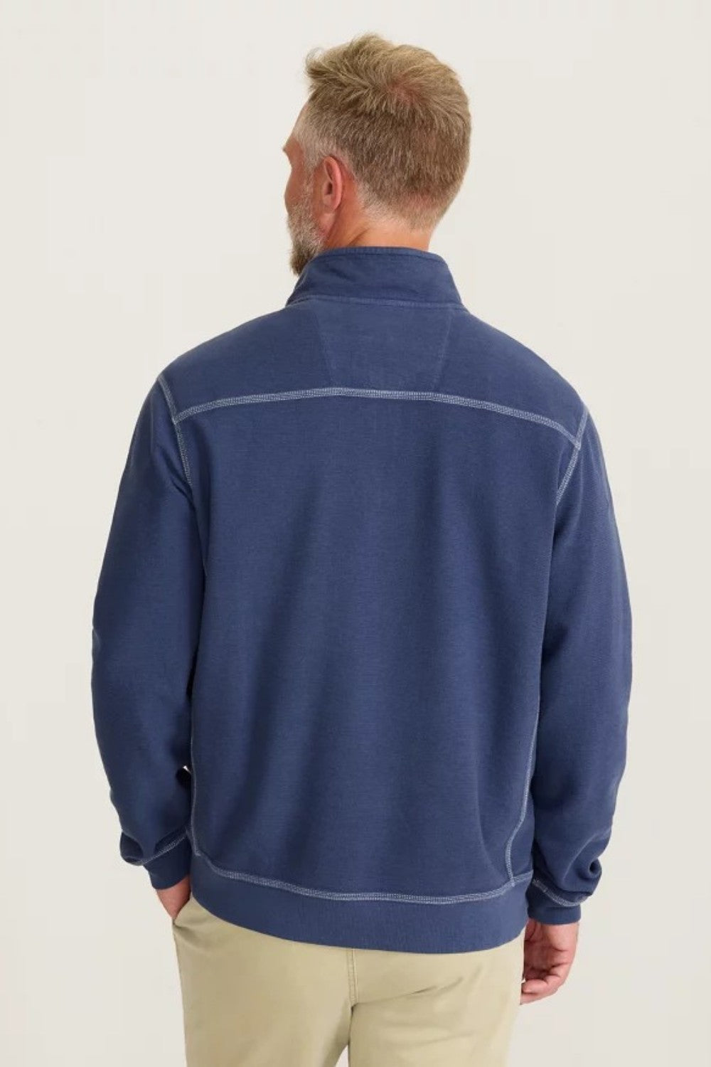 Man wearing a blue fleece jacket on a light background